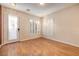 Bright living room featuring wood floors, white plantation shutters, and a glass-paneled door at 8234 Misty Sage St, Las Vegas, NV 89139