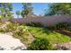 Landscaped backyard featuring a grassy area surrounded by flower beds and a tall block wall at 8262 Huxley St, Las Vegas, NV 89123