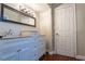 Updated bathroom with light blue vanity with drawers and a bronze trimmed mirror and vanity light at 8262 Huxley St, Las Vegas, NV 89123