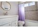 Bathroom featuring a white vanity, a large shower/tub combo with custom tile and a window at 8262 Huxley St, Las Vegas, NV 89123