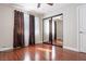 Bedroom features wood floors, a double window with curtains, and mirrored closet doors at 8262 Huxley St, Las Vegas, NV 89123