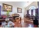 Elegant dining room with hardwood floors, complemented by a chandelier, large arched window, and curated artwork at 8262 Huxley St, Las Vegas, NV 89123