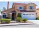 Charming two-story home featuring a red tile roof, stucco facade, manicured landscaping, and attached two-car garage at 8262 Huxley St, Las Vegas, NV 89123