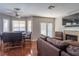 Comfortable living room and dining area with a fireplace and a large window offering natural light and charm at 8262 Huxley St, Las Vegas, NV 89123