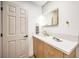 Modern bathroom with a wood vanity, white countertop, gold fixtures, and a stylish lit mirror at 8645 Edmond St, Las Vegas, NV 89139