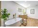 Modern bathroom showcasing a standalone tub, double vanity, stylish mirrors, and wood-look floors at 8645 Edmond St, Las Vegas, NV 89139