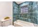 Bathroom featuring teal tile, a shower head, and a bathtub at 8645 Edmond St, Las Vegas, NV 89139