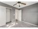 Comfortable bedroom featuring neutral carpeting, grey walls, a ceiling fan and closet at 8699 Grand Sequoia St, Las Vegas, NV 89139