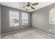 Carpeted bedroom with grey walls, ceiling fan, and large windows for ample natural light at 8699 Grand Sequoia St, Las Vegas, NV 89139