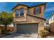 Two-story home with tan stucco, a two car garage, and desert landscaping at 8699 Grand Sequoia St, Las Vegas, NV 89139