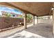 Covered patio area with concrete floor, brick wall surround, and arched column supports at 8699 Grand Sequoia St, Las Vegas, NV 89139