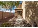 Side yard with rock landscaping, sidewalk, and a tan two-story house at 8699 Grand Sequoia St, Las Vegas, NV 89139