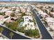 An aerial view showcases the neighborhood and community, with homes featuring white roofs and lush greenery at 8800 Las Olivas Ave, Las Vegas, NV 89147