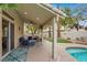 Covered backyard patio with ceiling fan, outdoor kitchen, and built in barbecue overlooking the pool at 8800 Las Olivas Ave, Las Vegas, NV 89147