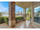 Charming front porch with stone pillars, offering a cozy seating area and views of the landscaped yard at 8800 Las Olivas Ave, Las Vegas, NV 89147