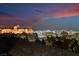 Nighttime city view overlooking lush landscaping and nearby buildings with a colorful sky at 9101 Alta Dr # 207, Las Vegas, NV 89145