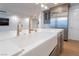 Contemporary kitchen with a marble island, farmhouse sink, and stainless steel refrigerator at 9101 Alta Dr # 207, Las Vegas, NV 89145