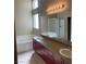 Bright bathroom featuring double sinks, a large mirror, and a separate bathtub at 9286 Blue Flax Pl, Las Vegas, NV 89148