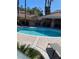 Community pool area featuring clear blue water, outdoor kitchen and surrounding lounge chairs at 9286 Blue Flax Pl, Las Vegas, NV 89148