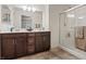 Bathroom featuring double sinks, granite countertops, and a glass-enclosed shower at 10525 Gibbous Moon Dr, Las Vegas, NV 89129