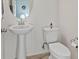 Powder room featuring a pedestal sink and toilet at 10525 Gibbous Moon Dr, Las Vegas, NV 89129