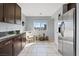 Spacious kitchen with stainless steel refrigerator, dark wood cabinets, and a view of the breakfast nook at 10525 Gibbous Moon Dr, Las Vegas, NV 89129