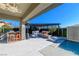 Outdoor living space with a covered patio, outdoor kitchen, pool, and cozy seating area at 10605 Harvest Green Way, Las Vegas, NV 89135