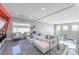 Open living room featuring modern decor, ample seating, and views of the backyard through glass railings at 10605 Harvest Green Way, Las Vegas, NV 89135