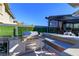 Modern outdoor kitchen with a built-in grill, sink, bar, and shaded pergola for outdoor entertaining at 10605 Harvest Green Way, Las Vegas, NV 89135