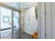 Modern glass-enclosed shower with sleek marble walls, rainfall showerhead, and view to the Primary bedroom at 10605 Harvest Green Way, Las Vegas, NV 89135