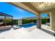 Backyard pool with a tranquil waterfall feature, surrounded by lush greenery and outdoor seating at 10605 Harvest Green Way, Las Vegas, NV 89135