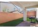 A covered patio sits next to a low maintenance artificial grass backyard at 10801 Far Country Ave, Las Vegas, NV 89129