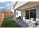 Relaxing backyard patio with outdoor seating, a grill, and a low-maintenance artificial grass lawn at 10801 Far Country Ave, Las Vegas, NV 89129