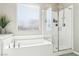 Bathroom features a tub with tile surround and glass enclosed shower at 10801 Far Country Ave, Las Vegas, NV 89129