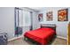 Stylish bedroom with a red bedspread, decorative wall art, window, and a laundry basket at 10801 Far Country Ave, Las Vegas, NV 89129