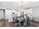 Bright dining room with white cabinets, stainless appliances, dark floors and a stylish chandelier at 10801 Far Country Ave, Las Vegas, NV 89129