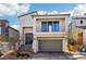 Contemporary two-story home featuring a balcony, gray garage door, and landscaped front yard at 10801 Far Country Ave, Las Vegas, NV 89129