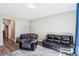 Comfortable living room featuring a gray recliner, a dark leather sofa and wood-look floors at 10801 Far Country Ave, Las Vegas, NV 89129