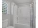 Bathroom featuring shower-tub combo, adjustable shower head and a window with white shutters at 11158 Antonine Wall Ct, Las Vegas, NV 89141