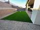 This backyard features well-maintained artificial turf, rock landscaping, and a sturdy brick retaining wall at 145 Medianoche St, Las Vegas, NV 89138