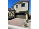 Two-story home with brick driveway, two-car garage, and desert landscaping under a bright blue sky at 145 Medianoche St, Las Vegas, NV 89138