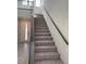 Carpeted staircase with a sleek metal railing leads to the upper floor of the home at 145 Medianoche St, Las Vegas, NV 89138