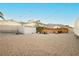 Spacious gravel backyard with shed, patio seating, and full fencing around the perimeter at 200 E Desert Rose Dr, Henderson, NV 89015