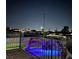 Backyard view of a rock waterfall feature above a lighted pool, viewed from a wooden deck at 200 E Desert Rose Dr, Henderson, NV 89015