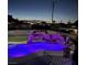 Backyard view of a lighted pool with a rock waterfall feature and a basketball hoop at 200 E Desert Rose Dr, Henderson, NV 89015