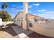 Backyard featuring a large concrete patio, gravel landscaping, mature palm trees, and stucco walls at 2045 Summit Pointe Dr, Las Vegas, NV 89117