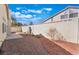 Backyard featuring a concrete patio, gravel landscaping, mature palm trees, and stucco walls at 2045 Summit Pointe Dr, Las Vegas, NV 89117