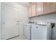 Laundry room with a side-by-side washer and dryer, cabinets, and tiled flooring at 2045 Summit Pointe Dr, Las Vegas, NV 89117