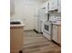 Clean kitchen includes white appliances and light wood-look flooring at 221 Mission Newport Ln # 208, Las Vegas, NV 89107