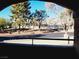 Neighborhood view from balcony featuring lush trees, community wall, and residential street in a suburban setting at 221 Mission Newport Ln # 208, Las Vegas, NV 89107